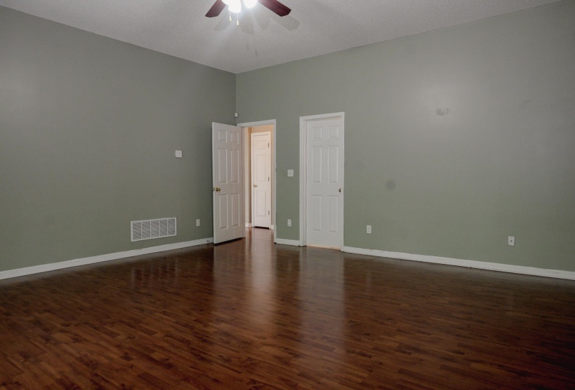 Spare room featuring a ceiling fan and dark wood-style flooring