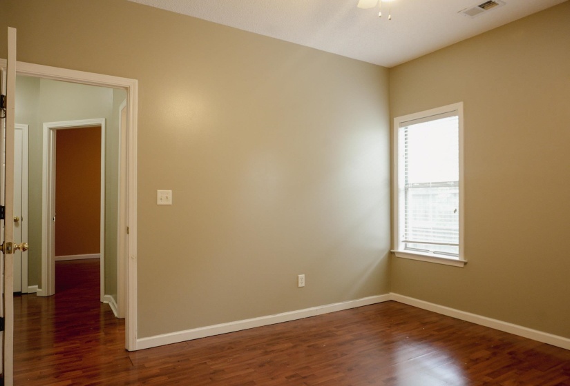 Empty room featuring dark wood-style flooring and a ceiling fan