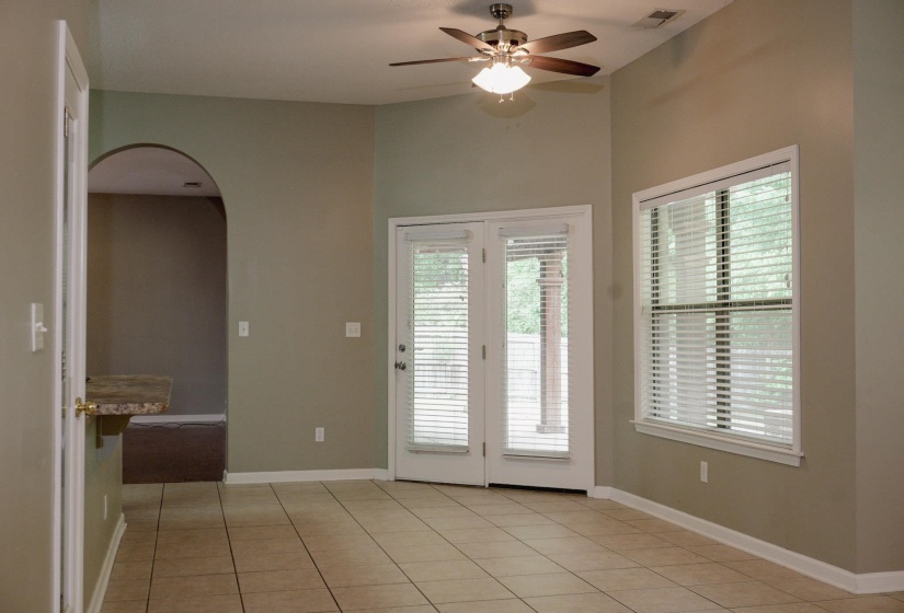 Doorway featuring arched walkways, a ceiling fan, and tile patterned floors