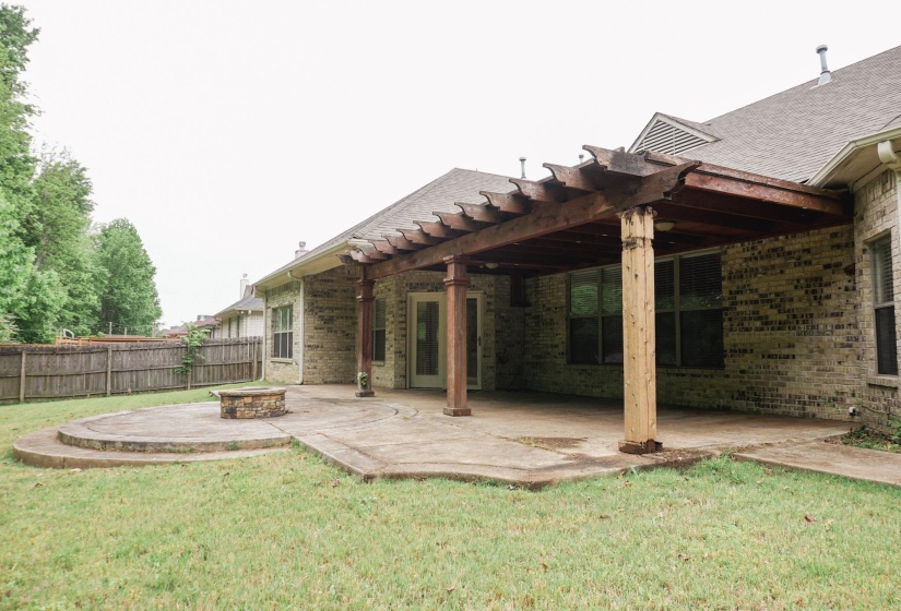 Rear view of property with brick siding, a patio area, a fire pit, and a pergola