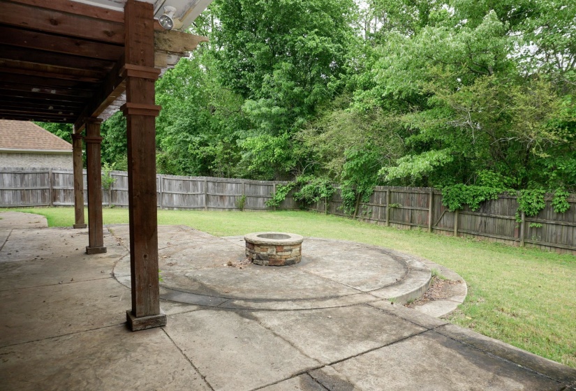 Fenced backyard with a patio, an outdoor fire pit, and a pergola