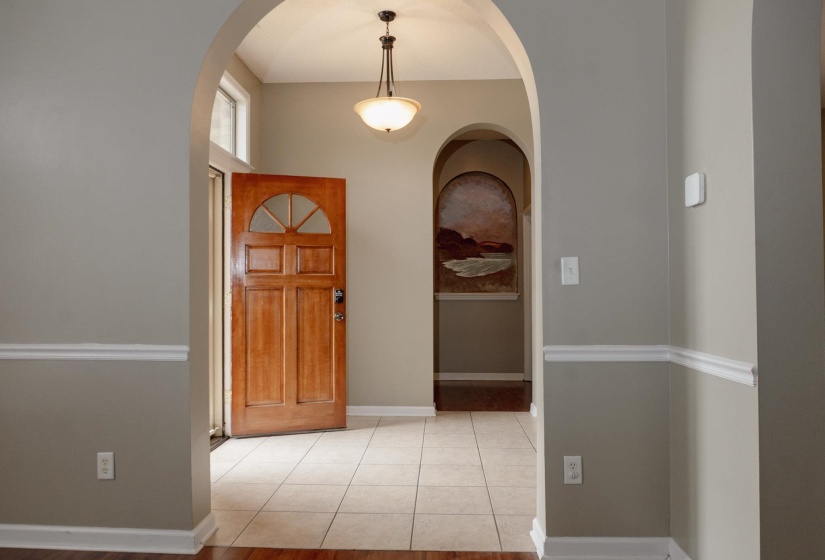 Entrance foyer featuring arched walkways and light tile patterned floors