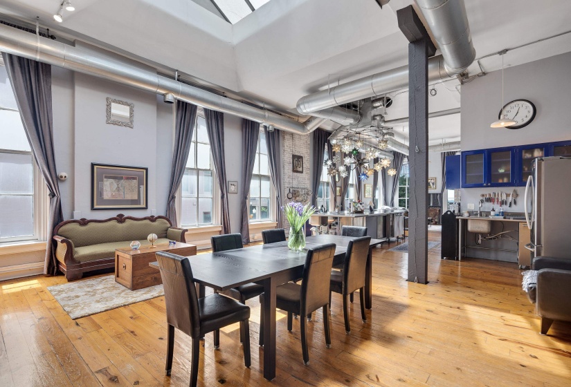 Dining room with light wood-style floors and a high ceiling