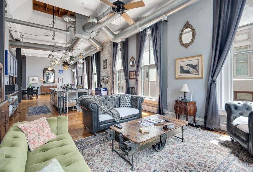 Living area featuring hardwood / wood-style floors, a high ceiling, and ceiling fan