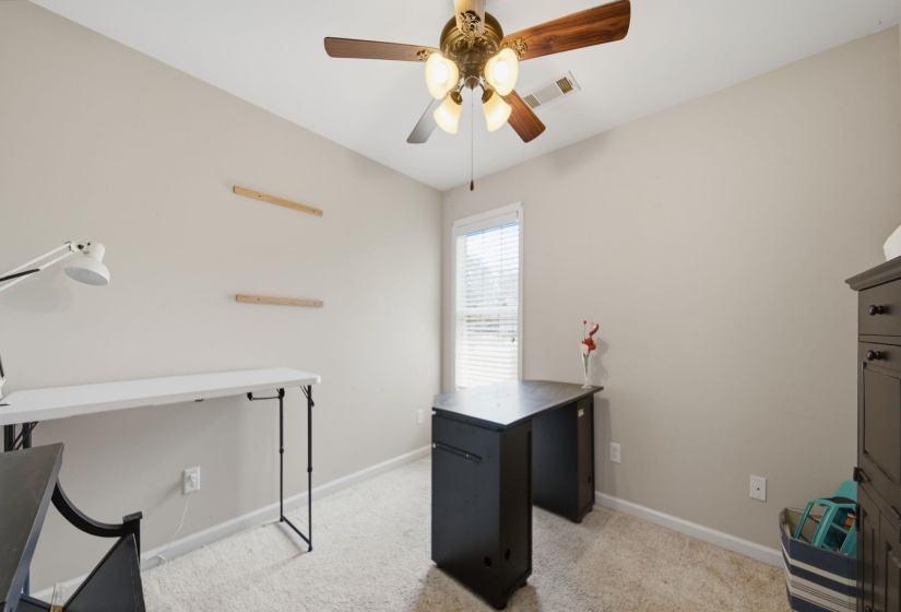 Office space with light carpet and ceiling fan