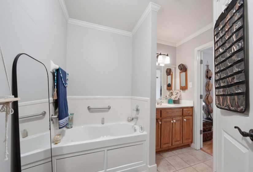 Full bathroom featuring a bath, vanity, light tile patterned floors, and crown molding