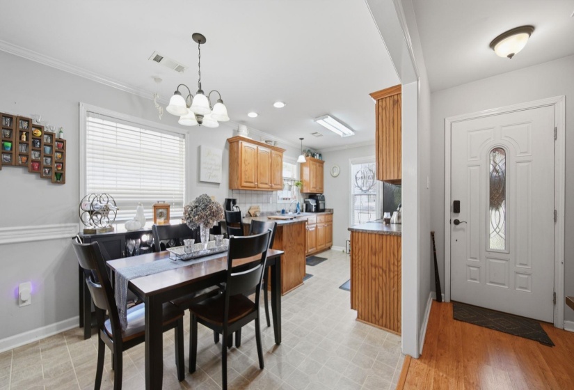 Dining space featuring crown molding and suspended lighting