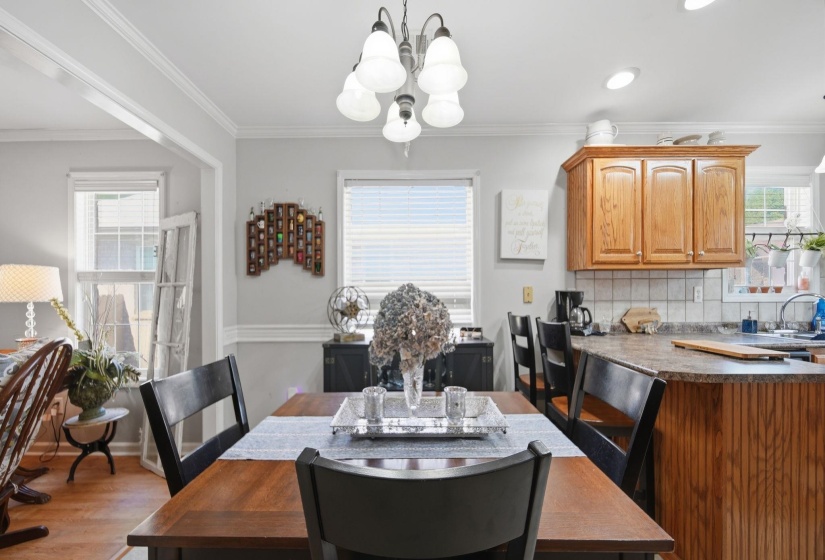 Dining room featuring crown molding, wood finished floors, and suspended lighting