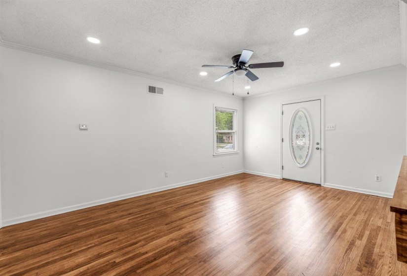 Empty room featuring wood finished floors, a textured ceiling, ceiling fan, and recessed lighting