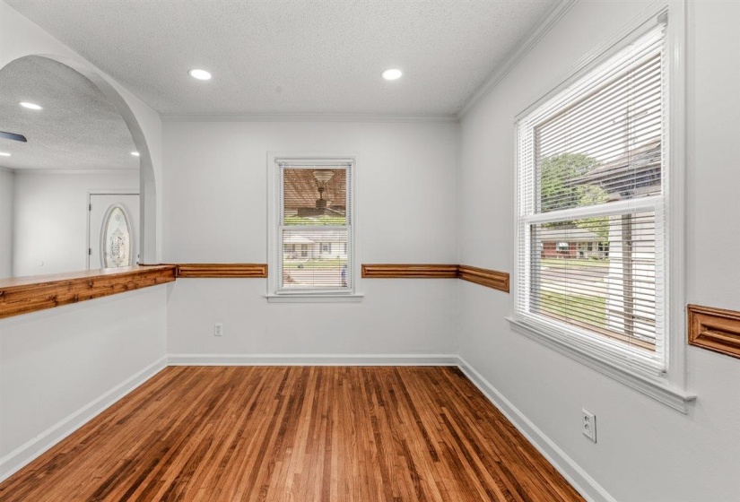 Unfurnished dining area featuring a textured ceiling, dark wood-style floors, healthy amount of natural light, arched walkways, and recessed lighting