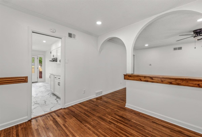 Spare room with arched walkways, ceiling fan, light wood finished floors, recessed lighting, and a textured ceiling