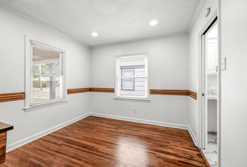 Unfurnished room with dark wood finished floors, a textured ceiling, recessed lighting, and crown molding