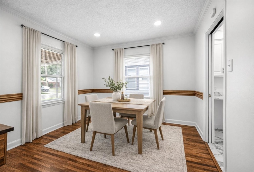 Dining space featuring dark wood-type flooring, ornamental molding, healthy amount of natural light, a textured ceiling, and recessed lighting