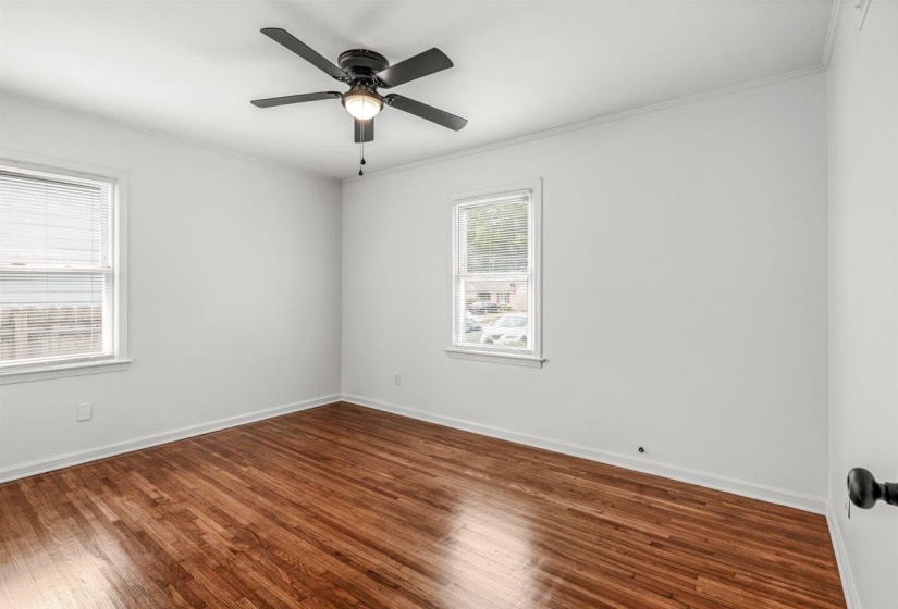Unfurnished room with dark wood-style flooring, ornamental molding, and ceiling fan
