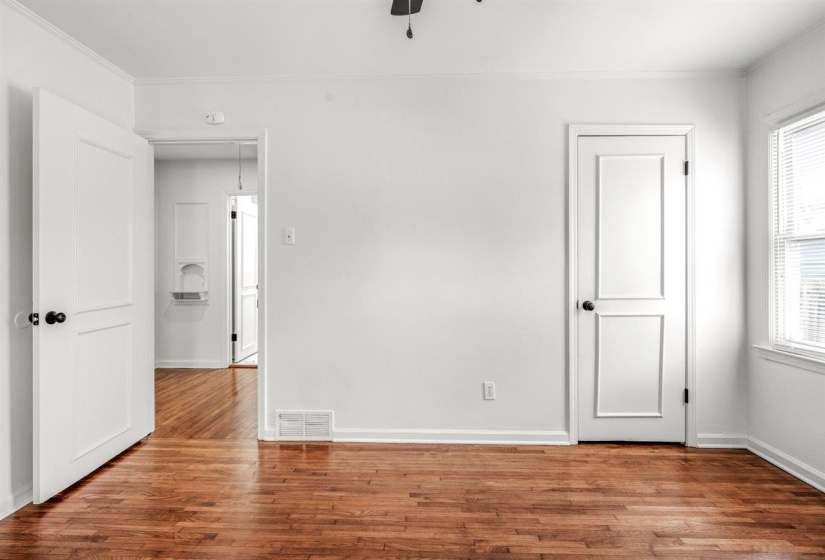 Unfurnished bedroom featuring dark wood-type flooring and ornamental molding