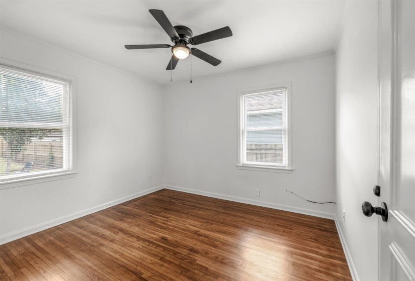 Spare room with dark wood-style floors, ceiling fan, and ornamental molding