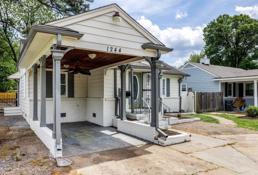 View of front of property featuring brick siding, a ceiling fan, a gate, and an attached carport