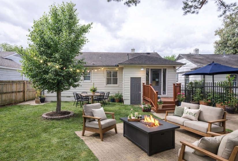 Rear view of property featuring a patio area, a fenced backyard, outdoor lounge area, and a fire pit