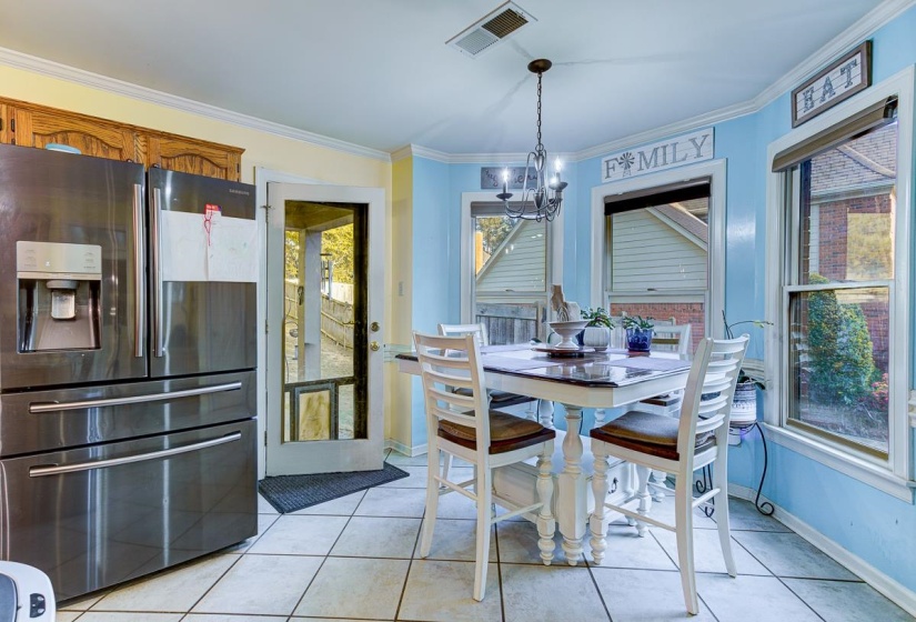Dining area featuring light tile patterned floors, ornamental molding, and suspended lighting