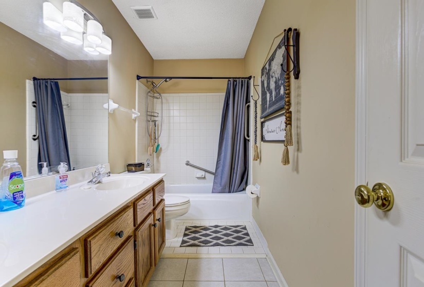 Full bathroom with vanity, light tile patterned floors, and shower / tub combo
