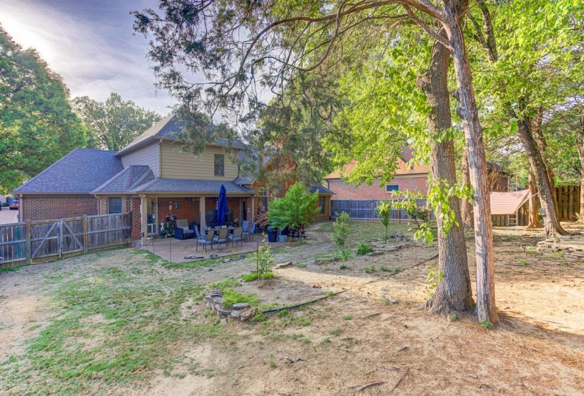 Back of house featuring a patio area, a fenced backyard, brick siding, and a shingled roof
