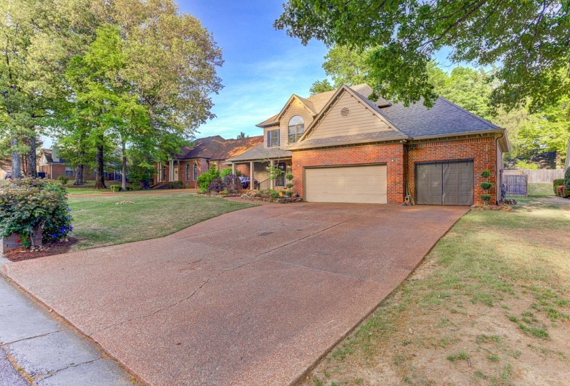 Traditional-style home with an attached garage, brick siding, concrete driveway, and a shingled roof
