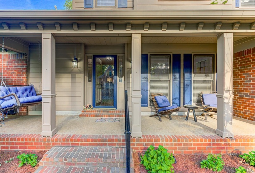 Property entrance with a porch and brick siding