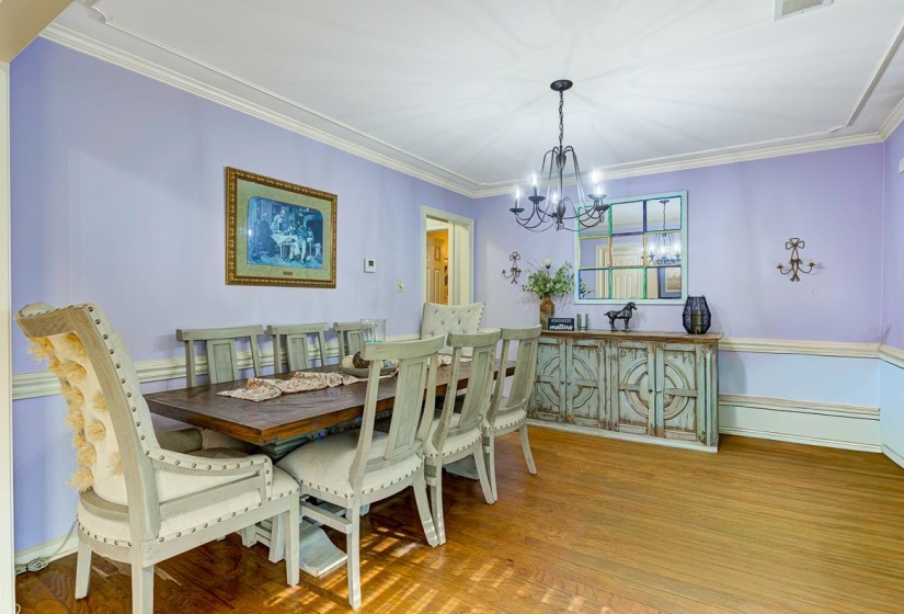 Dining space featuring crown molding, wood finished floors, and suspended lighting