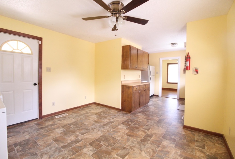 Kitchen with stone finish floors, light countertops, wood finish cabinetry, and ceiling fan