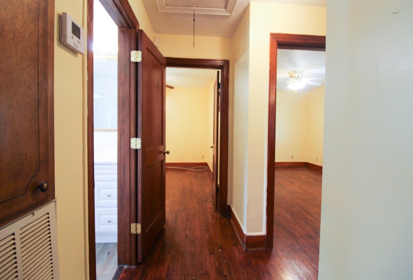 Hallway with attic access and dark wood-style floors