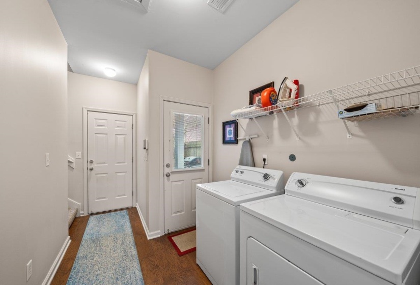 Laundry area featuring dark wood-type flooring and washer and clothes dryer