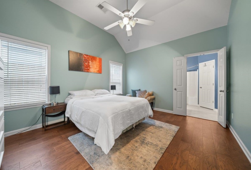 Bedroom featuring dark wood-style floors, vaulted ceiling, and a ceiling fan