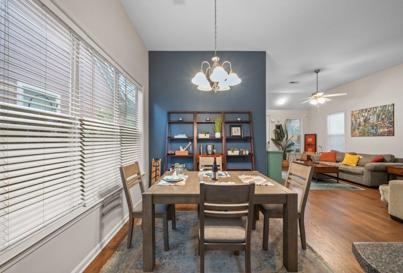 Dining space with suspended lighting, dark wood-type flooring, and ceiling fan