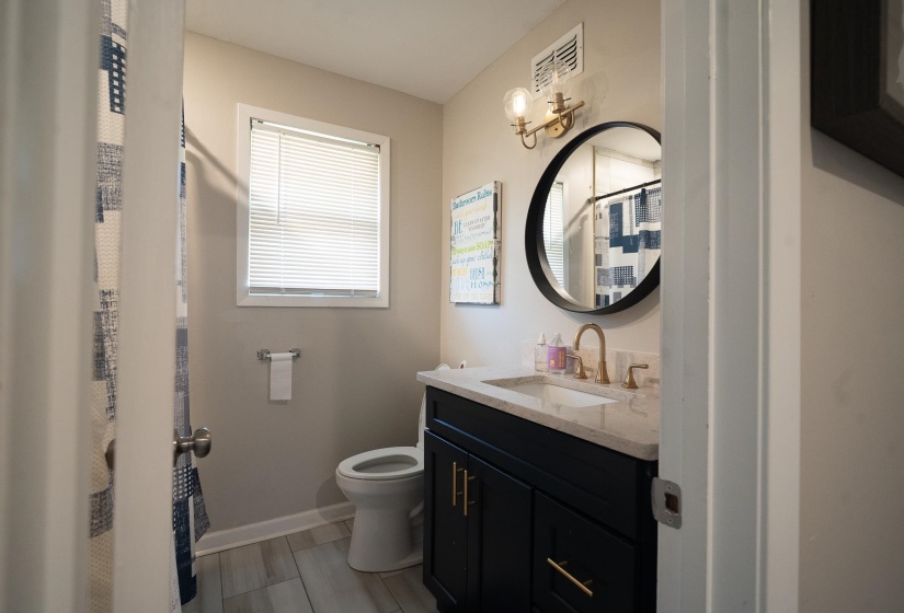 Bathroom with vanity, a shower with curtain, and light wood-style floors