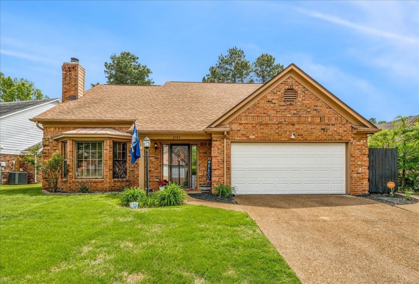 View of front of home with brick siding, driveway, roof with shingles, and an attached garage
