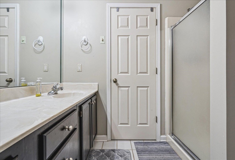 Bathroom with a shower stall, vanity, and light tile patterned floors