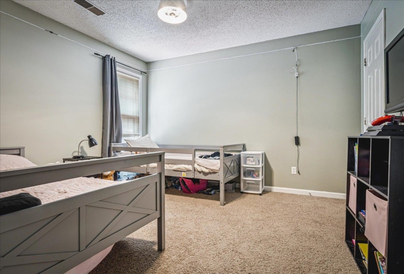 Bedroom featuring a textured ceiling and light carpet