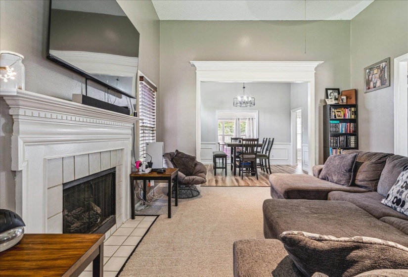 Living room featuring a fireplace, hanging lights, and a decorative wall
