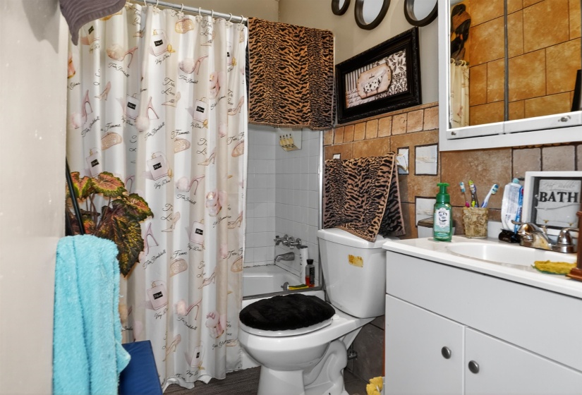 Bathroom with vanity, tile walls, and shower / tub combo