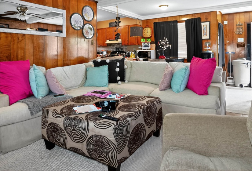 Living room featuring wood walls and a ceiling fan