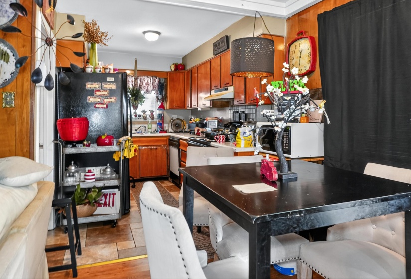Kitchen featuring freestanding refrigerator, white microwave, light countertops, range, and wood finish cabinetry
