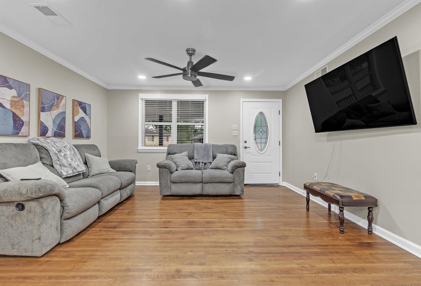 Living area featuring ornamental molding, light wood-style flooring, ceiling fan, and recessed lighting