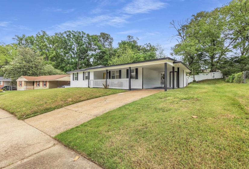 Ranch-style house featuring driveway, an attached carport, and covered porch