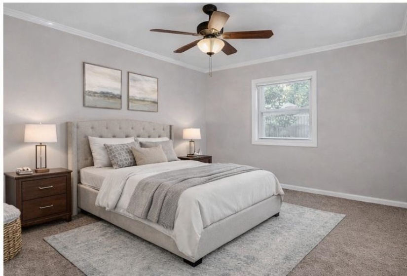 Carpeted bedroom with crown molding and ceiling fan
