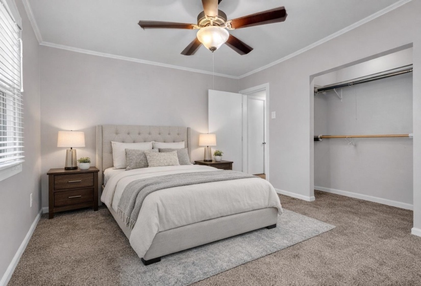 Bedroom featuring crown molding, ceiling fan, carpet, and a closet
