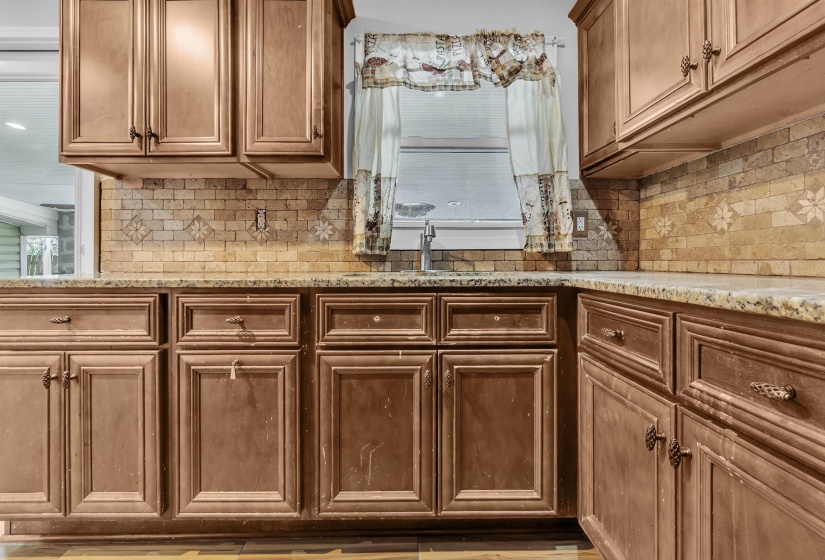 Kitchen featuring light stone counters and wood finish cabinets