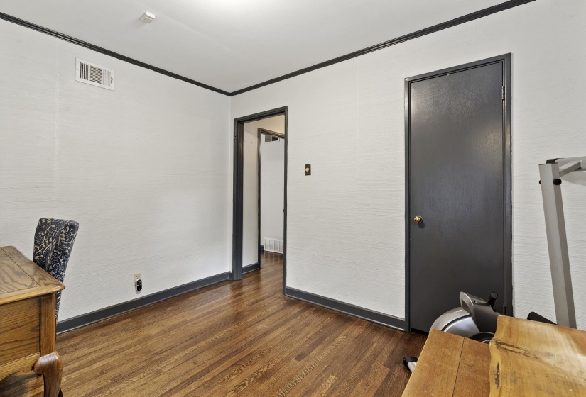 Office area with crown molding and dark wood-style floors