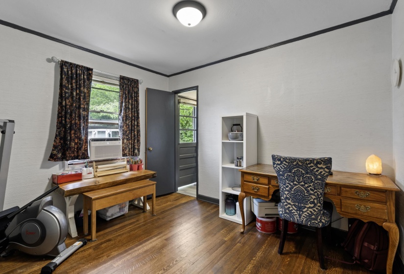 Office area featuring dark wood-style floors, crown molding, and cooling unit