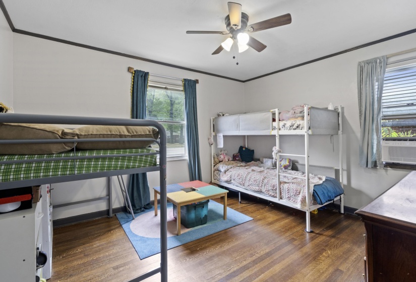 Bedroom featuring dark wood finished floors, a ceiling fan, and crown molding
