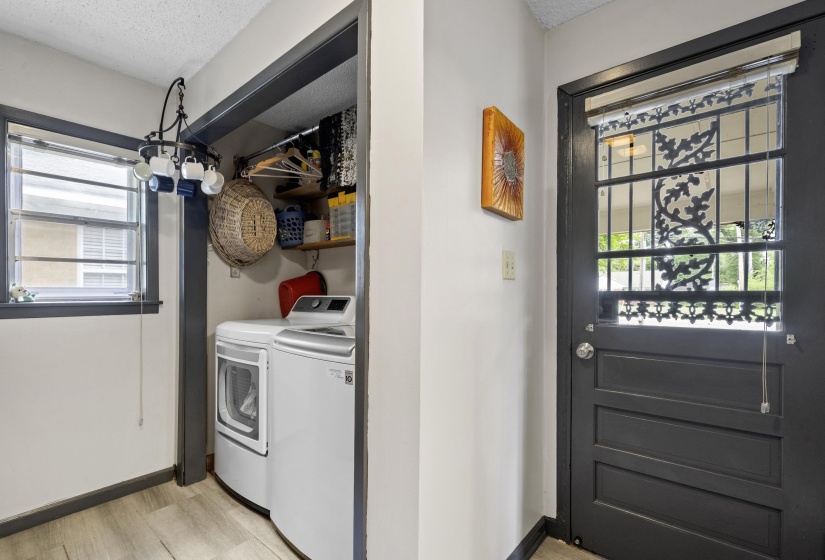 Laundry area featuring a textured ceiling, washer and dryer, and light wood-type flooring